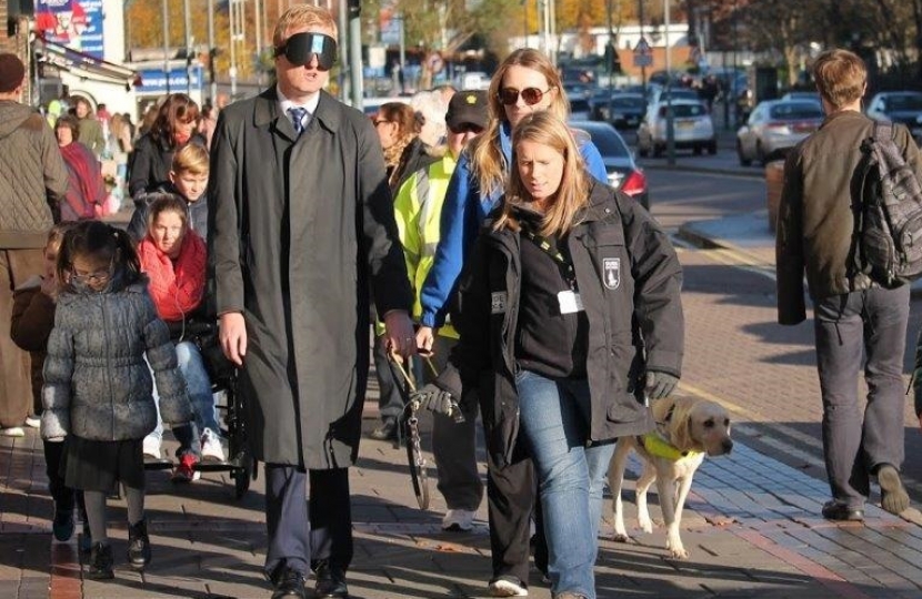 Oliver Dowden MP walking Shenley Road, Borehamwood, during a sight loss simulation event.